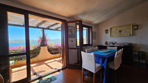 a dining room with a table and a view of the ocean at LA TERRAZZA SUL MARE - panoramic cottage overlooking sea and Caprera island in a quiet residential area - 150 mt from the sea in La Maddalena