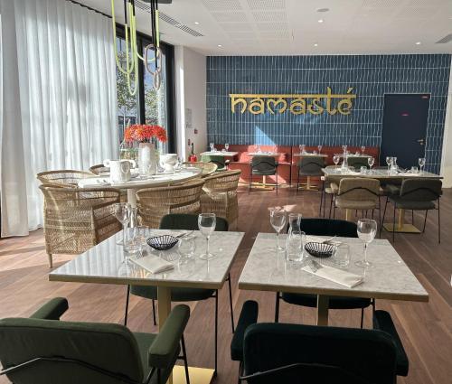 un restaurante con mesas y sillas y copas de vino en RESIDENCE SERVICES MONTANA Paris Clichy, en Clichy