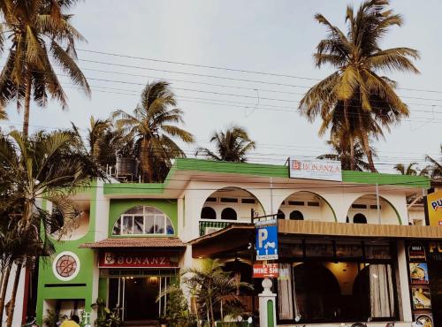 a building with palm trees in front of it at Hotel Bonanza in Baga