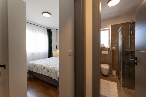 - une chambre avec un lit et une salle de bains pourvue d'une douche dans l'établissement Holiday Lux, à Podstrana