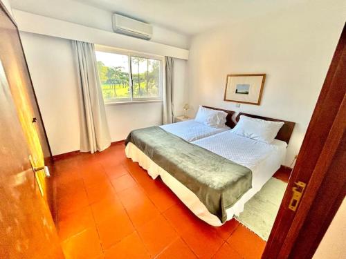 um quarto com uma cama grande e uma janela em Heart of Quinta do Lago ! em Faro