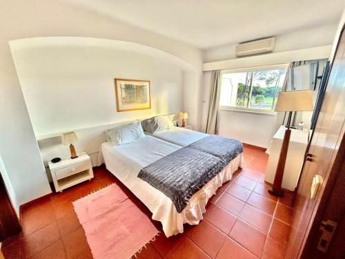 um quarto com uma cama e uma grande janela em Heart of Quinta do Lago ! em Faro