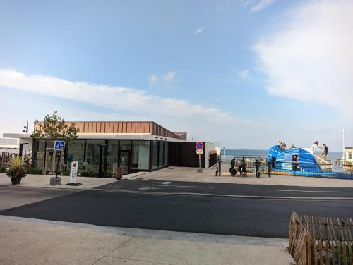 een gebouw met een waterglijbaan naast de oceaan bij Charmante maison front de mer et centre ville in Luc-sur-Mer