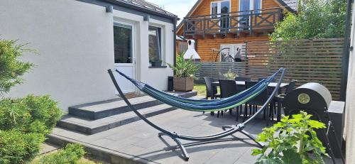 eine Hängematte auf einer Terrasse vor einem Haus in der Unterkunft DOMKI KAJUTA in Żarnowska