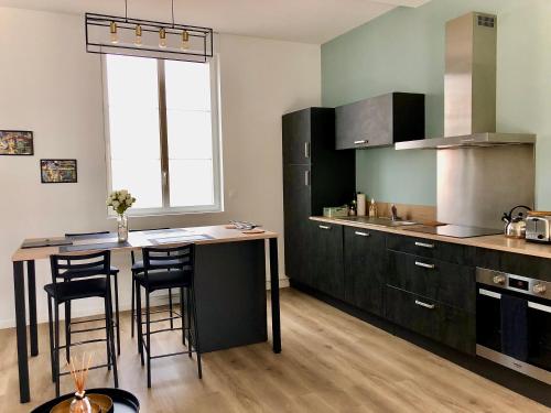 una cucina con tavolo e alcune sedie di Maison Gabriel Appartement LUNE a Abbeville