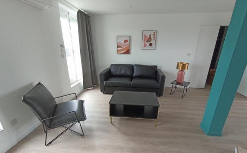 a living room with a black couch and a table at Hotel de Champagne in Épernay