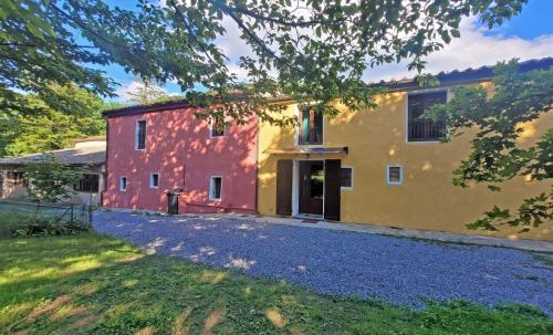 a house with a red and yellow building at Locanda Le Panche in Pistoia