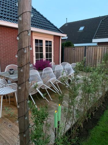 eine Terrasse mit Stühlen und einem Tisch im Hinterhof in der Unterkunft B&B slapen in de veenhoop in De Veenhoop