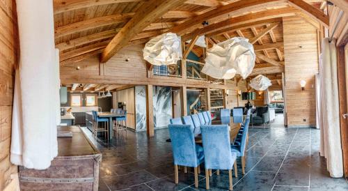 een eetkamer met houten plafonds en blauwe stoelen bij Les Chalets d'Adelphine & SPA in Les Gets