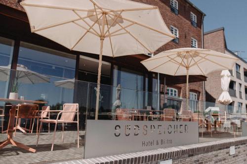 two umbrellas are sitting outside of a restaurant at Südspeicher in Kappeln