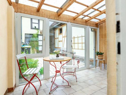 d'une terrasse avec une table, des chaises et des fenêtres. dans l'établissement Ferienwohnung Brühler Hof, à Bad Berka