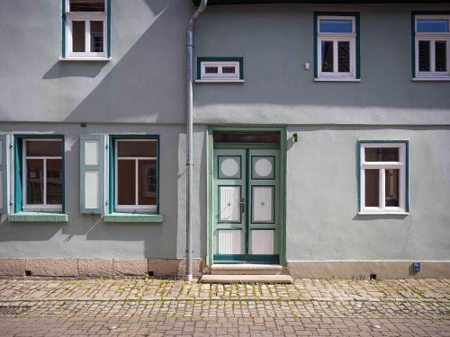 une maison avec une porte et des fenêtres vertes dans l'établissement Ferienwohnung Brühler Hof, à Bad Berka