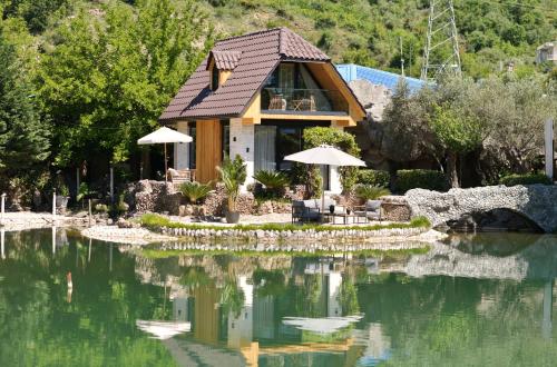 a house sitting on top of a large body of water at Kompleksi Turistik DEA in Shkodër