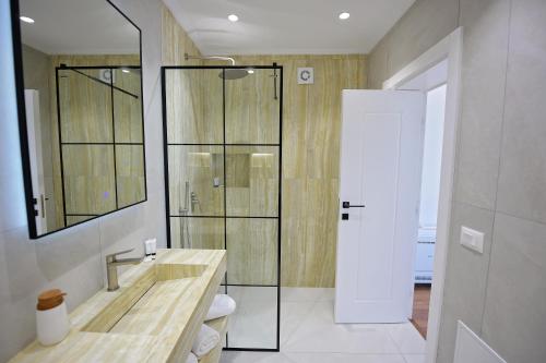 a bathroom with a sink and a glass shower at Kompleksi Turistik DEA in Shkodër