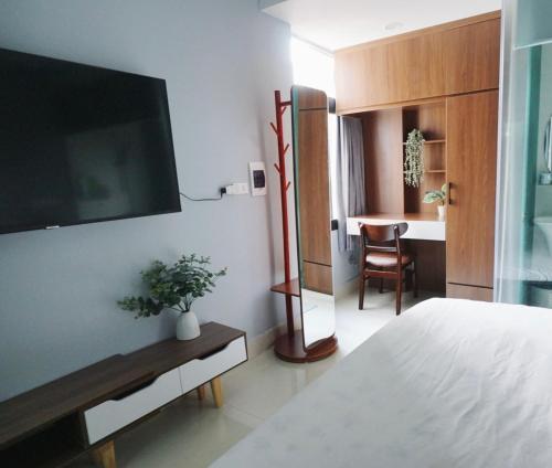 ein Schlafzimmer mit einem Bett und einem TV an der Wand in der Unterkunft Niah Cozy Home - Train Street in Hanoi