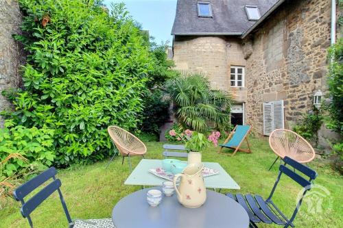 une terrasse avec des chaises et une table avec un vase. dans l'établissement Ty glaz, à Dinan