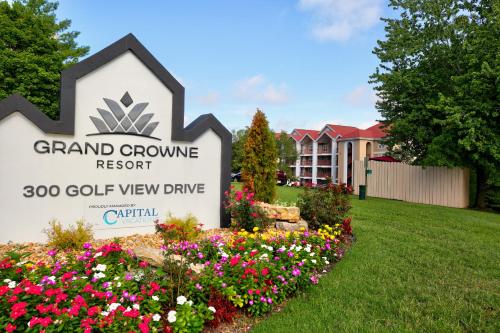 een bord voor Grand Grove Resort met bloemen bij Grand Crowne Resort in Branson