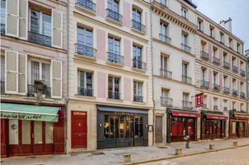 un edificio en una calle con tiendas delante en Lovely Apartment Palace of Versailles, en Versalles