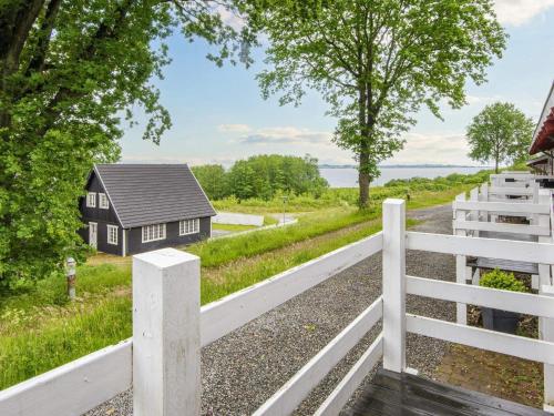 een huis aan de kant van een weg met een wit hek bij 5 person holiday home in Aabenraa in Aabenraa