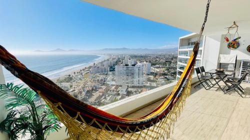 a hammock in a room with a view of the beach at La Choza VIP Roja in Coquimbo