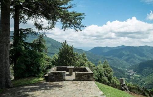 una panchina in pietra su una collina con vista sulle montagne di Rectoria Santuari del Coll a Girona