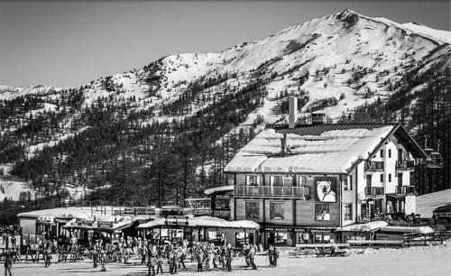 ein schwarz-weißes Foto eines Skiresorts mit einem Berg in der Unterkunft Orso Bianco Hotel & Chalet in Sauze dʼOulx