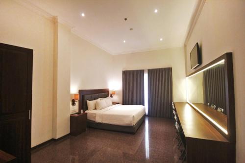 een hotelkamer met een bed en een televisie bij Grand Rohan Jogja in Yogyakarta