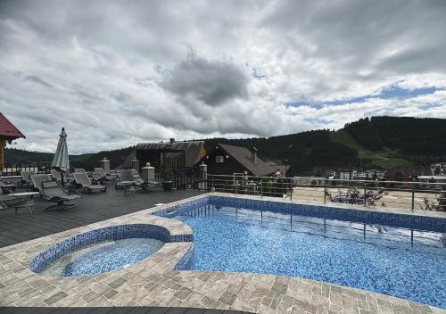 - une piscine sur une terrasse avec vue sur la montagne dans l'établissement Didukh Eco Hotel&Spa, à Bukovel