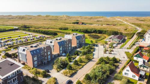 une vue aérienne sur un bâtiment avec un parking dans l'établissement Duinerei appartement C102, à Callantsoog