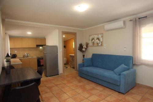 a living room with a blue couch and a kitchen at Olga Home Agios Ioannis Lefkada - Lefkada BnB in Lefkada Town