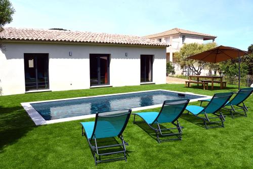 a pool with chairs and an umbrella in a yard at Casa Solana - Piscine privée et chauffée in Galeria