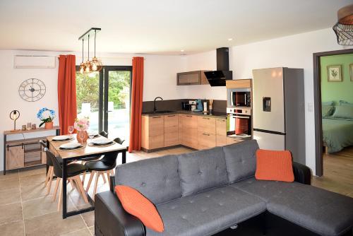 a living room with a couch and a table and a kitchen at Casa Solana - Piscine privée et chauffée in Galeria