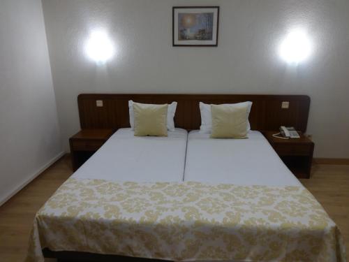 a bedroom with a bed with white sheets and pillows at Hotel Sinagoga in Tomar