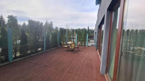 d'un balcon avec une table et des chaises. dans l'établissement Silver Mountain, Duplex 3 camere - 250 mp luxury garden - Poiana Brasov, à Braşov