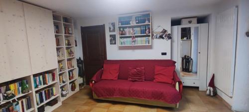 a living room with a red couch and bookshelves at Alexi cir 0009 in Chambave