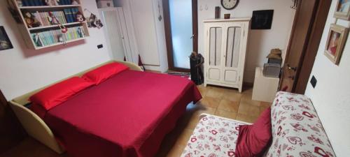 a bedroom with a red bed and a chair at Alexi cir 0009 in Chambave