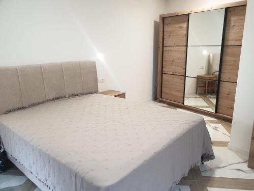 a white bed in a room with a large window at PALAR Apartment in Ljubljana