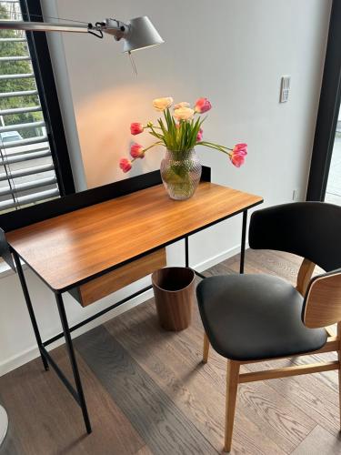 a desk with a vase of flowers on it at Zum EM Stadion zu Fuß - Luxus im Grünen in Cologne