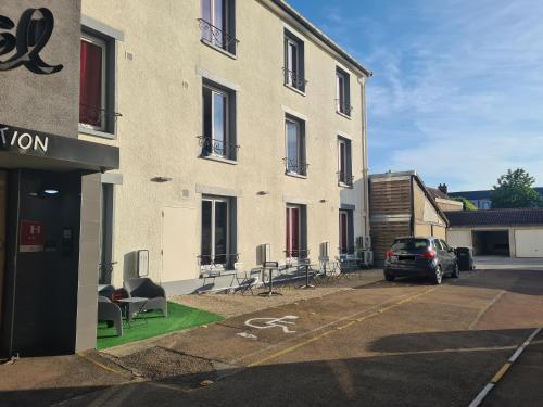 een auto geparkeerd op een parkeerplaats naast een gebouw bij Logis Hôtel du Cirque Troyes centre historique in Troyes