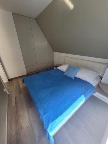 a bed in a room with a blue blanket on it at Apartamenty Platinum in Łukęcin