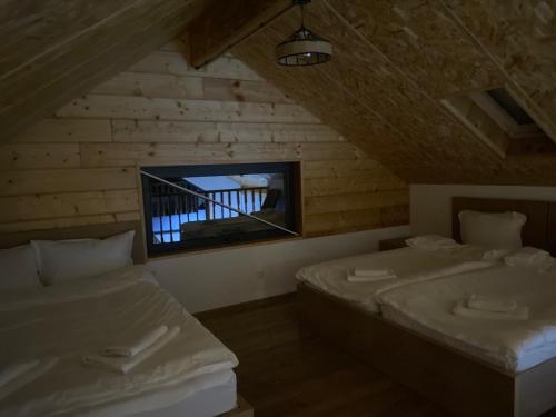 Cette chambre mansardée comprend 2 lits et une télévision. dans l'établissement Kokhta Villa In Bakuriani, à Bakuriani