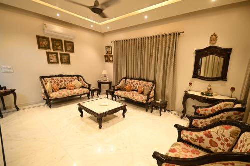 ein Wohnzimmer mit 2 Sofas und einem Couchtisch in der Unterkunft Hadendra Residences in Jaipur