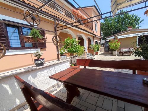 un tavolo e sedie in legno su un patio di M&R apartmani Rovinj a Rovigno (Rovinj)