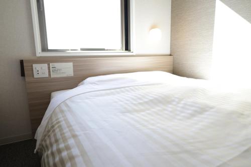 Llit o llits en una habitació de Super Hotel Sano Fujioka