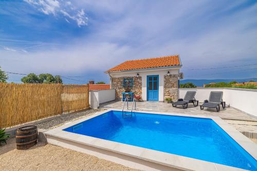 una piccola piscina blu di fronte a una casa di Holiday house KUNTENTA with pool and jacuzzi a Skrbčići