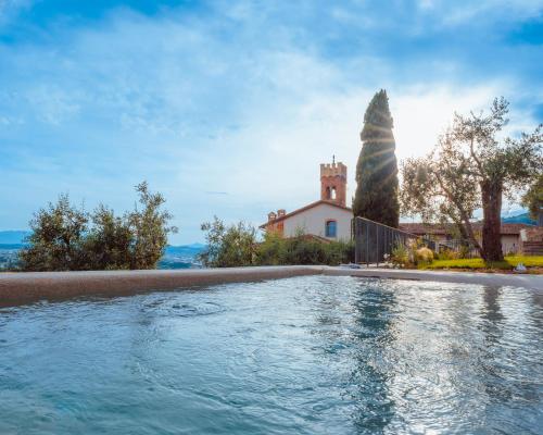 einem Pool vor einem Haus mit einem Gebäude in der Unterkunft La Monastica Resort & Spa in Borgo a Buggiano