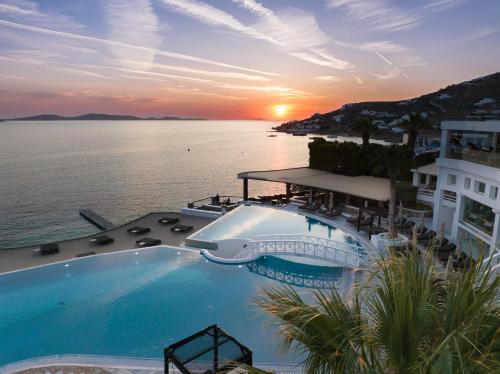 - une piscine sur le côté d'un bâtiment donnant sur l'océan dans l'établissement Saint John Hotel Villas & Spa, à Agios Ioannis Mykonos