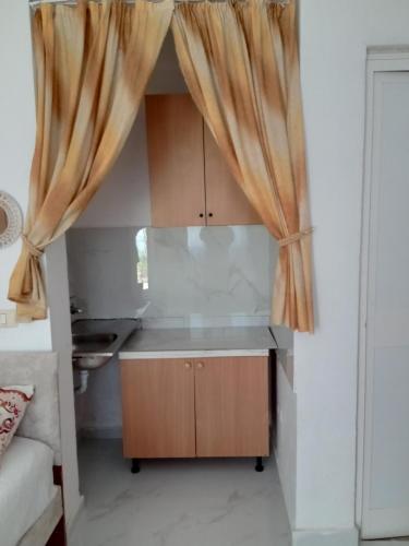 una pequeña cocina con cortinas en una habitación en Prime rooms, en Durrës