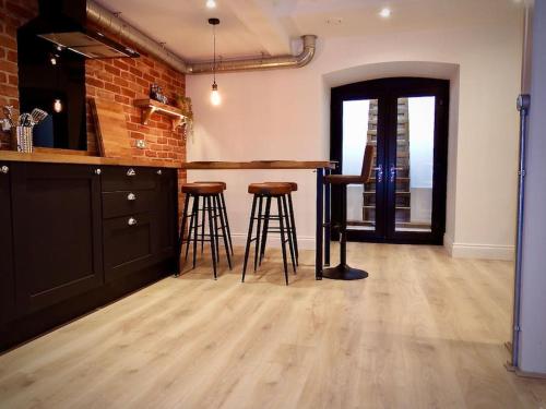 uma cozinha com um bar com bancos e uma parede de tijolos em Newly Renovated Stunning Warehouse Apartment em Bournemouth