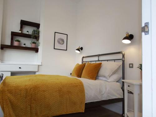 um quarto com uma cama com um cobertor amarelo em Newly Renovated Stunning Warehouse Apartment em Bournemouth